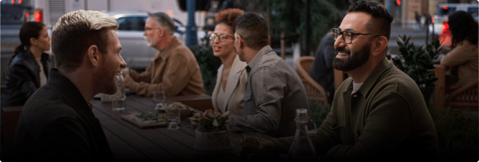 Two men are speaking at a restaurant.